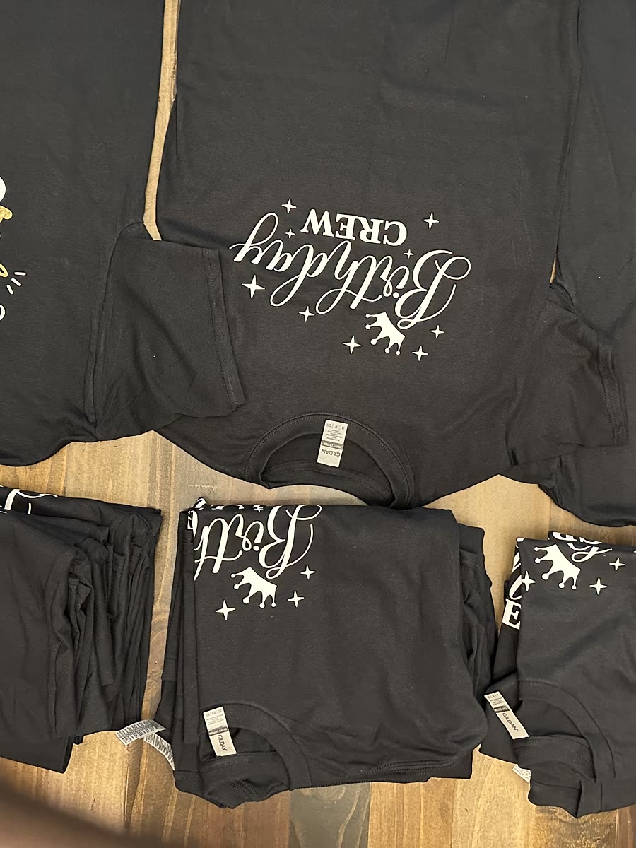 A set of matching black tees and shorts printed with birthday crew, laid out together before delivery.
