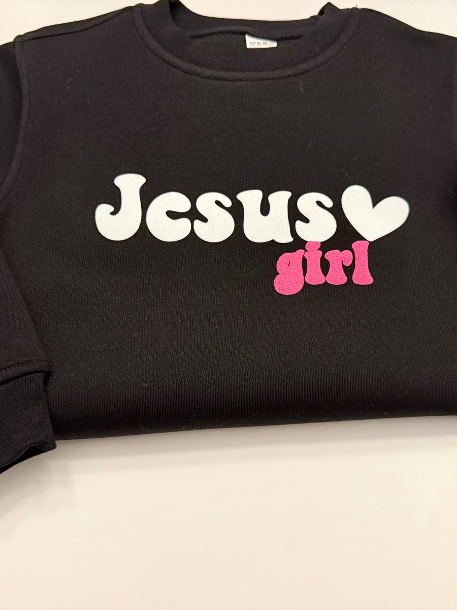 A black sweatshirt printed Jesus in white with a heart and girl in pink, with pink hearts down one sleeve.