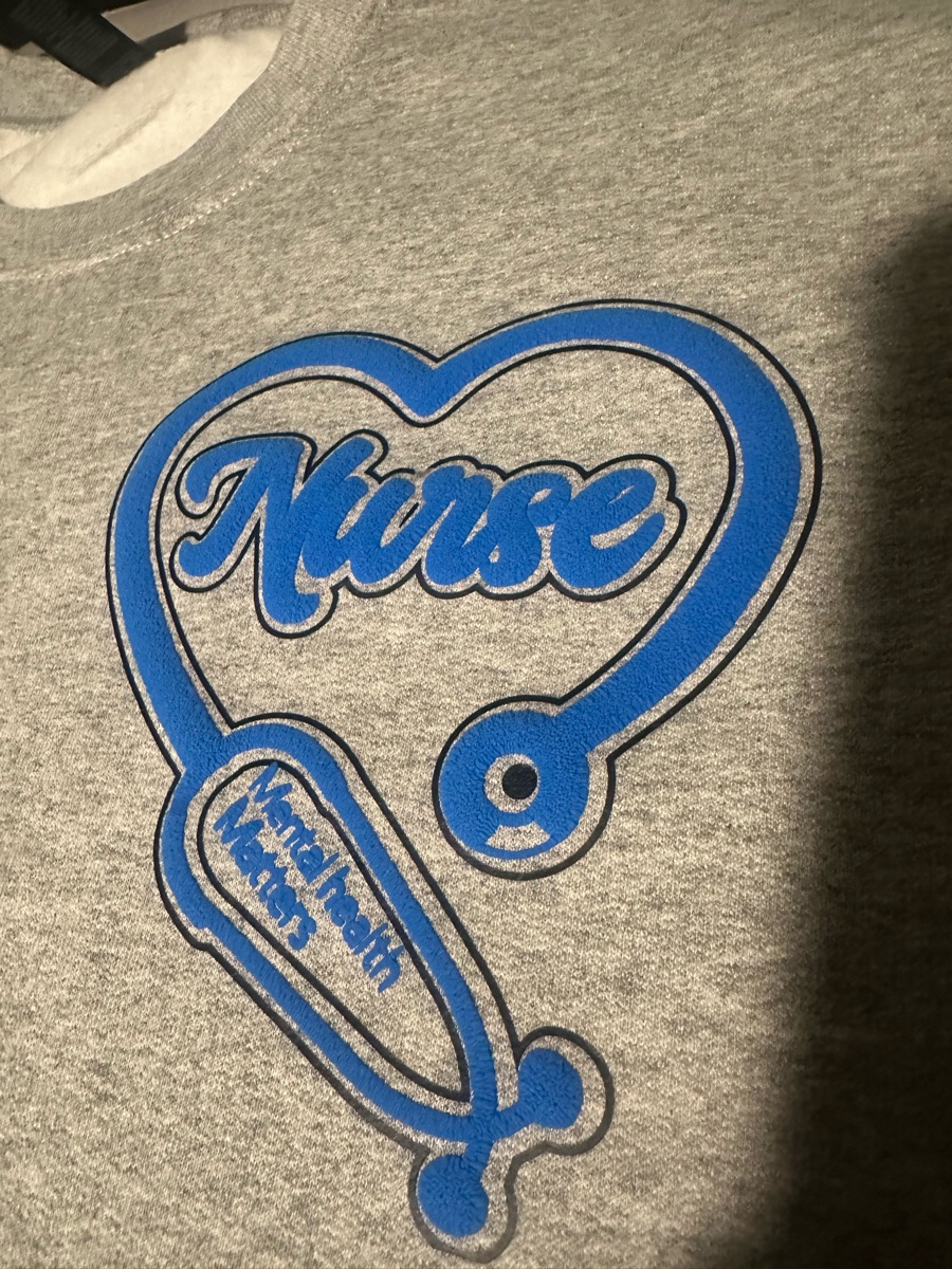 A grey sweatshirt printed Nurse in blue script inside a blue stethoscope bent into a heart, with mental health matters along the tubing.