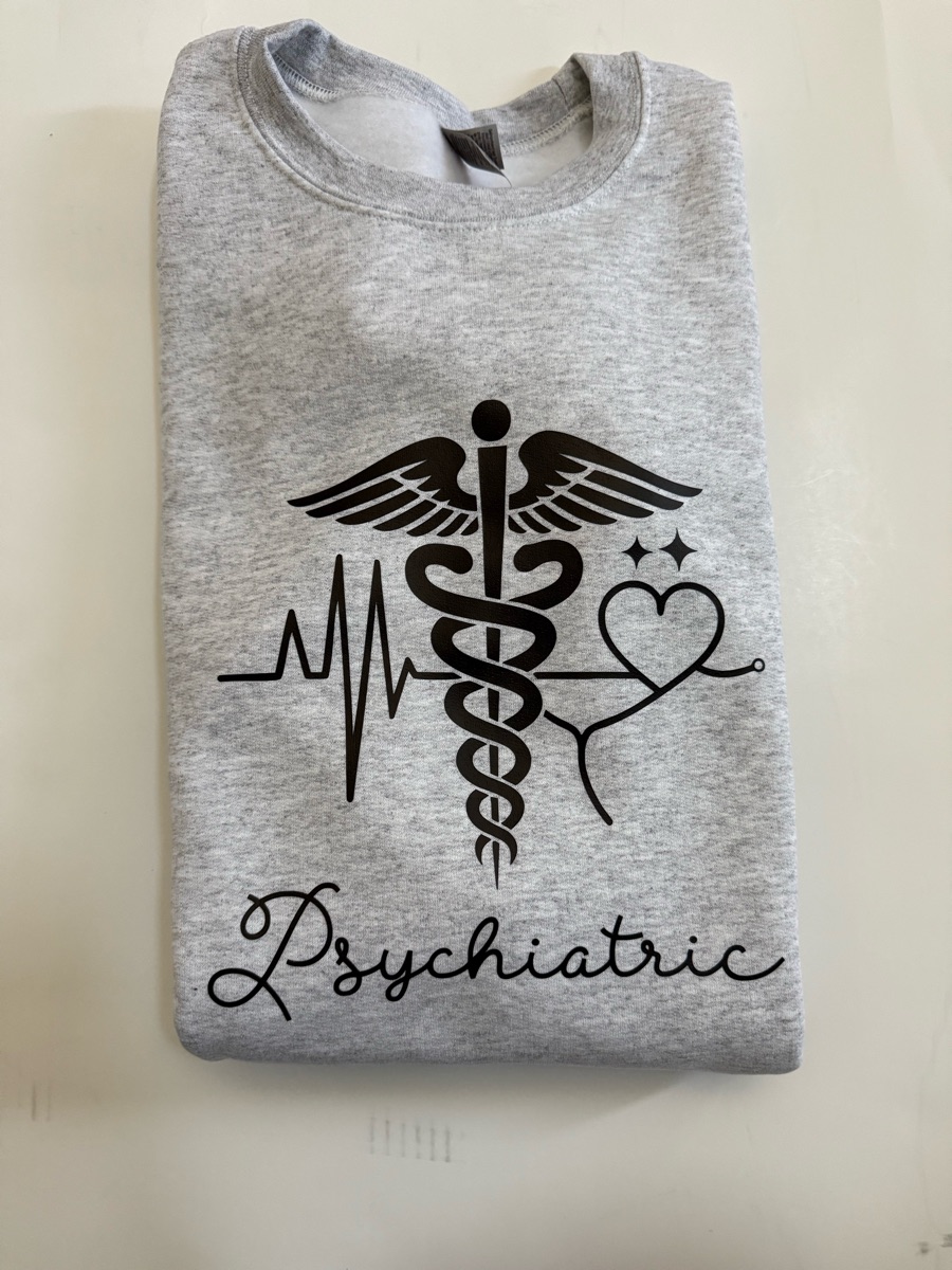 A heather grey sweatshirt printed with a black caduceus between a heartbeat line and a heart, with Psychiatric in script underneath.