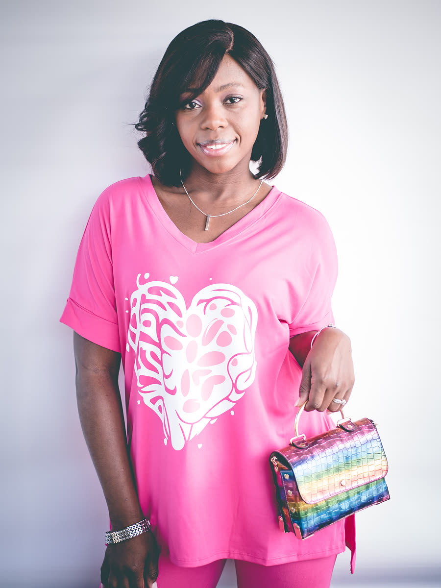 A bright pink tee printed with the white tree heart, worn with matching pink trousers.