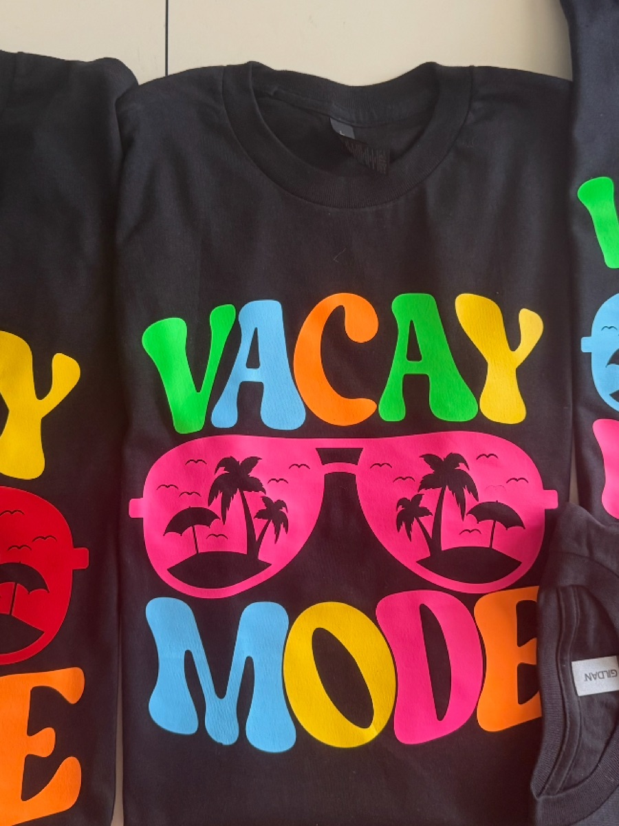 Black tees for one group trip, each printed VACAY MODE in rainbow letters around hot pink sunglasses with palm trees in the lenses.