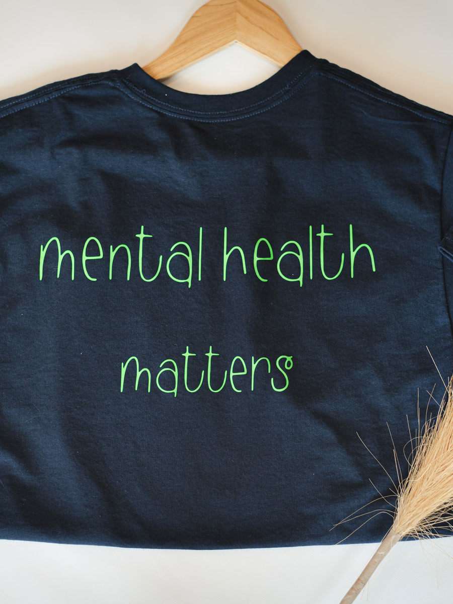 A navy tee reading mental health matters in green script.