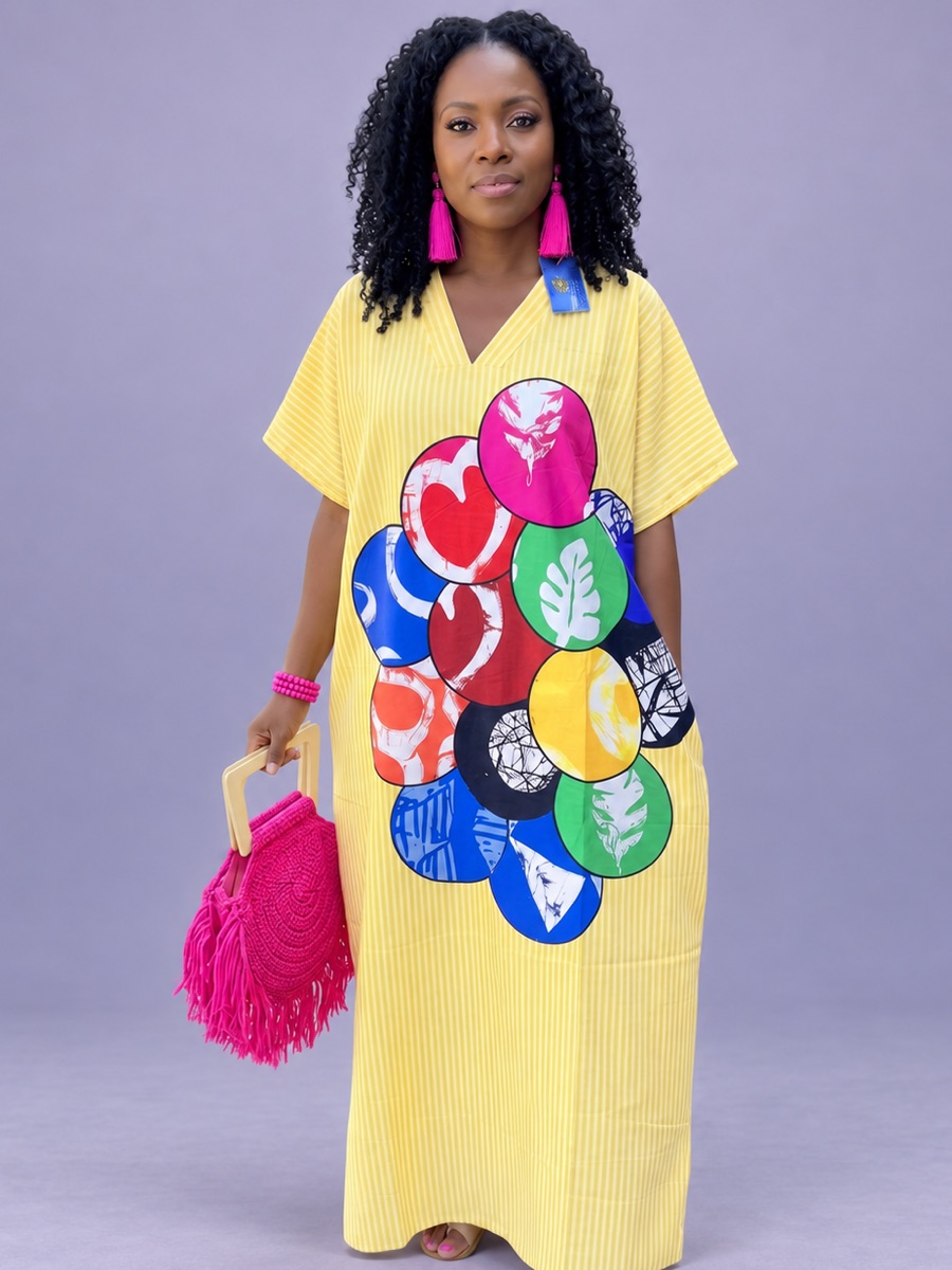 A woman in a yellow striped maxi kaftan with a cluster of patterned circles down the front.