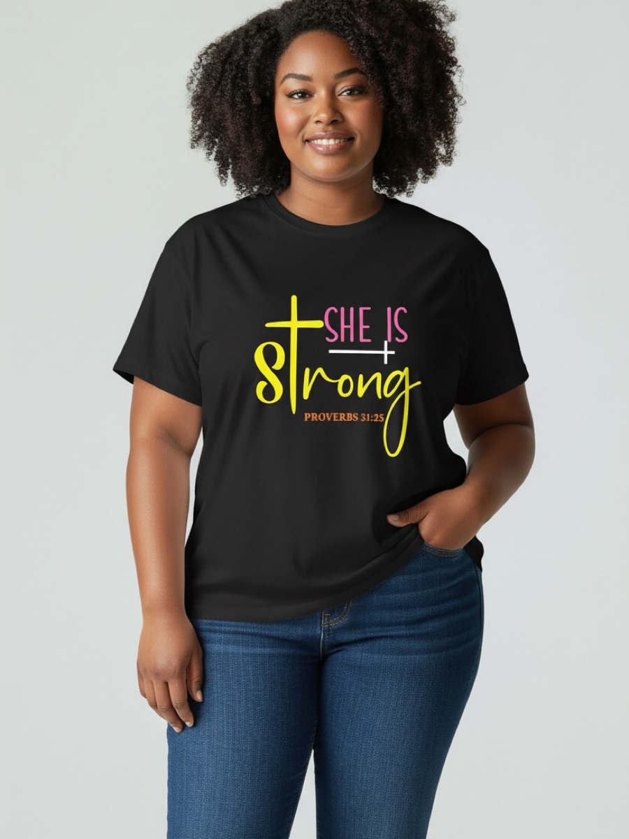 A woman in a black tee printed she is strong in pink and yellow, with a yellow cross for the t and Proverbs 31:25 underneath.